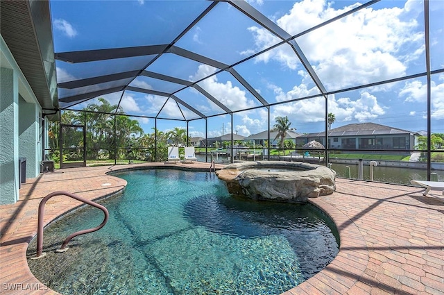 view of swimming pool with glass enclosure, an in ground hot tub, a water view, and a patio