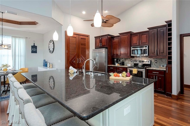 kitchen featuring ceiling fan, sink, stainless steel appliances, dark hardwood / wood-style floors, and decorative light fixtures