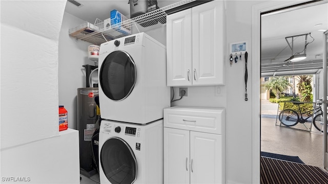 washroom featuring stacked washer and clothes dryer and water heater