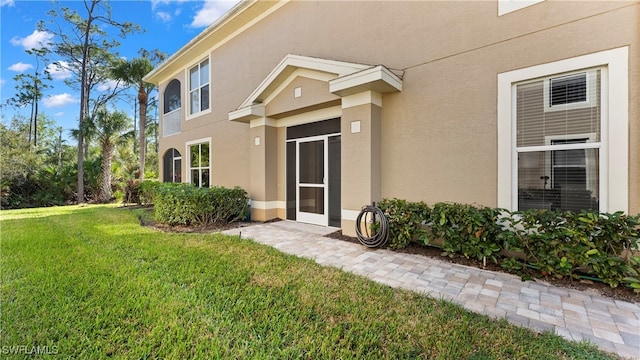 view of exterior entry with a yard