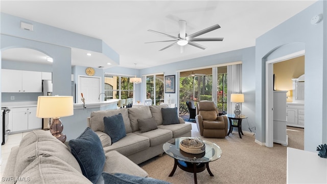 carpeted living room with ceiling fan