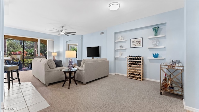 living room with carpet, built in shelves, and ceiling fan