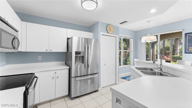 kitchen with appliances with stainless steel finishes, sink, white cabinetry, and pendant lighting