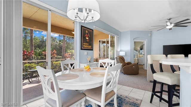 dining room with ceiling fan with notable chandelier and light tile patterned floors