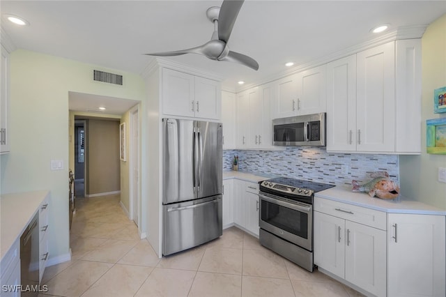 kitchen with backsplash, ceiling fan, appliances with stainless steel finishes, light tile patterned flooring, and white cabinetry