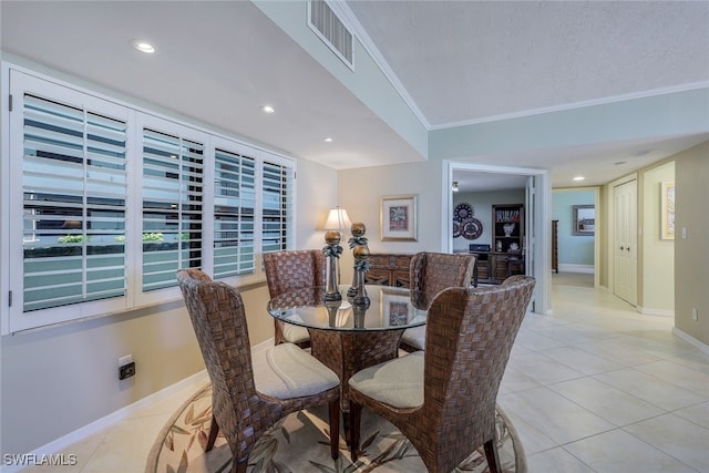 dining room featuring a textured ceiling, light tile patterned flooring, and crown molding