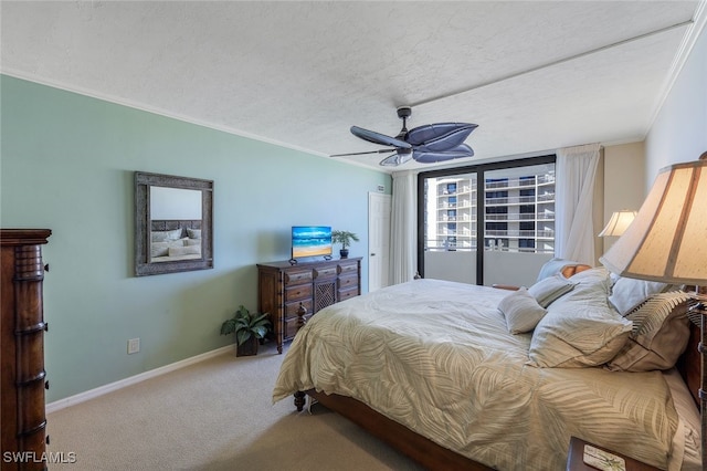 carpeted bedroom with ceiling fan, a textured ceiling, and ornamental molding