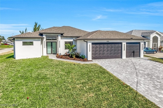 prairie-style home with a garage, a front lawn, decorative driveway, and stucco siding