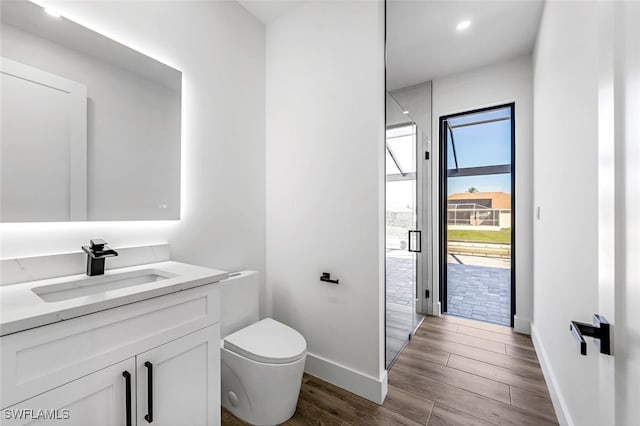 bathroom with hardwood / wood-style flooring, vanity, and toilet