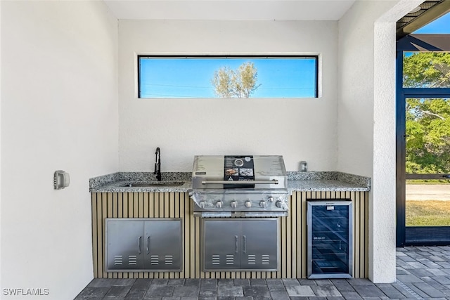 view of patio with wine cooler, grilling area, and a sink