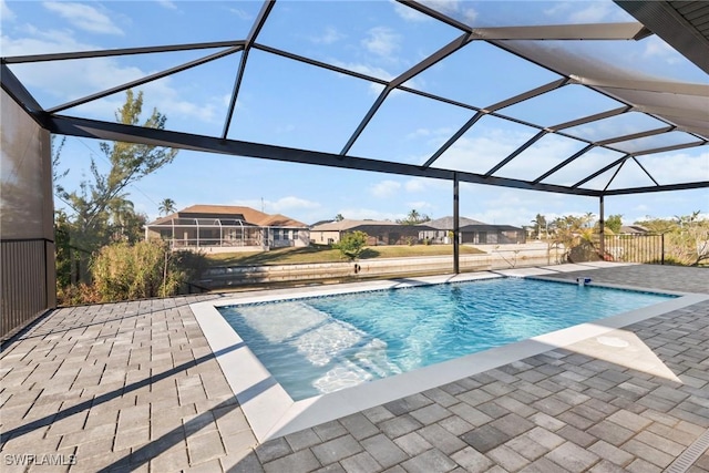 outdoor pool featuring a residential view, glass enclosure, and a patio