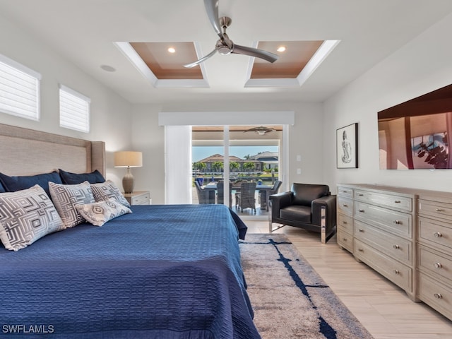 bedroom featuring a raised ceiling, ceiling fan, access to exterior, and multiple windows