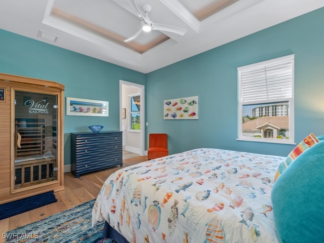 bedroom with a tray ceiling, ceiling fan, and hardwood / wood-style flooring