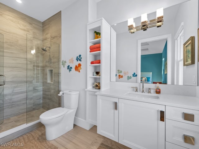 bathroom with hardwood / wood-style floors, vanity, toilet, and walk in shower