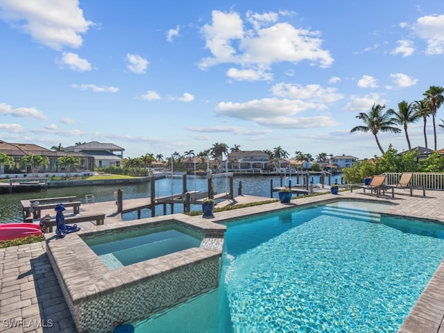 view of swimming pool featuring an in ground hot tub, a boat dock, a water view, and a patio area