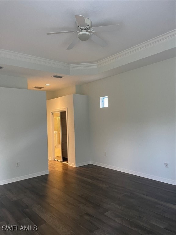 empty room featuring ceiling fan, dark hardwood / wood-style flooring, crown molding, and a tray ceiling