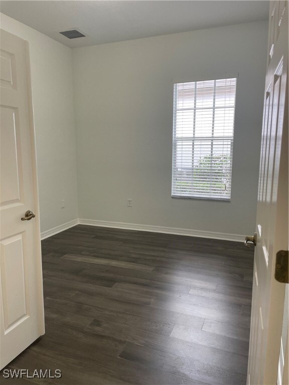 unfurnished room featuring dark hardwood / wood-style floors