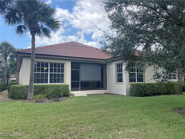 rear view of house featuring a lawn