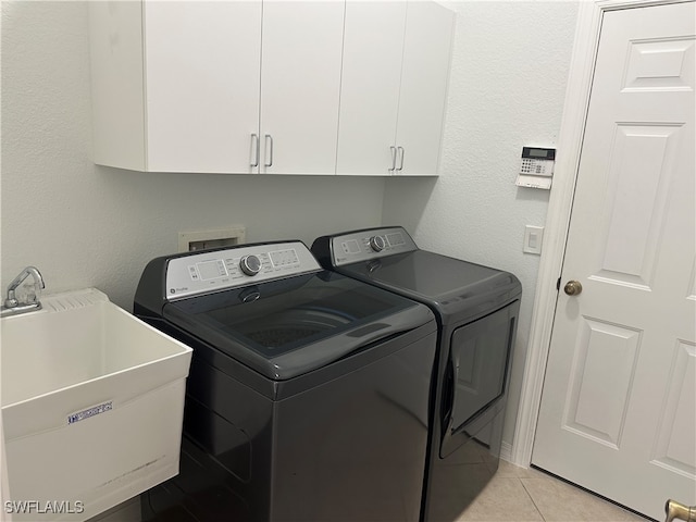 laundry area featuring cabinets, independent washer and dryer, sink, and light tile patterned flooring