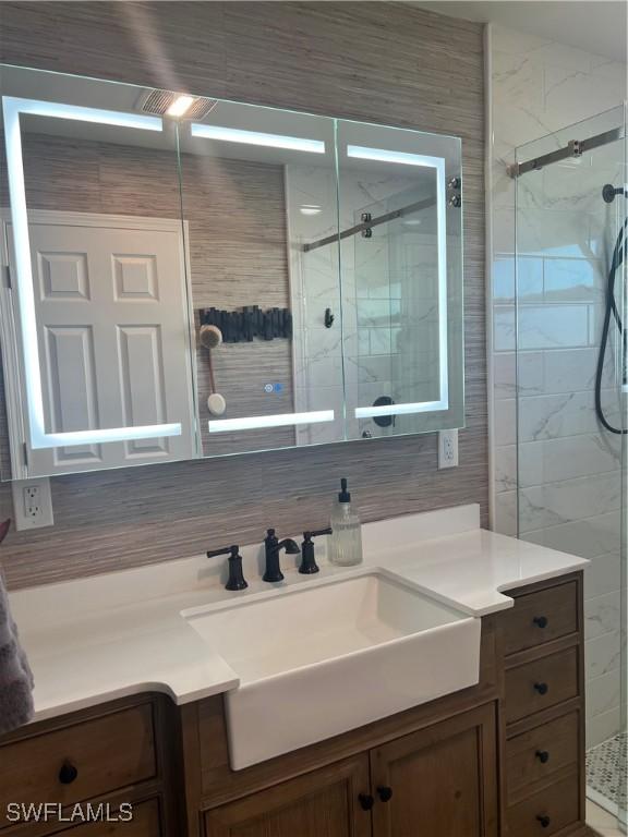 bathroom featuring vanity and a shower with door