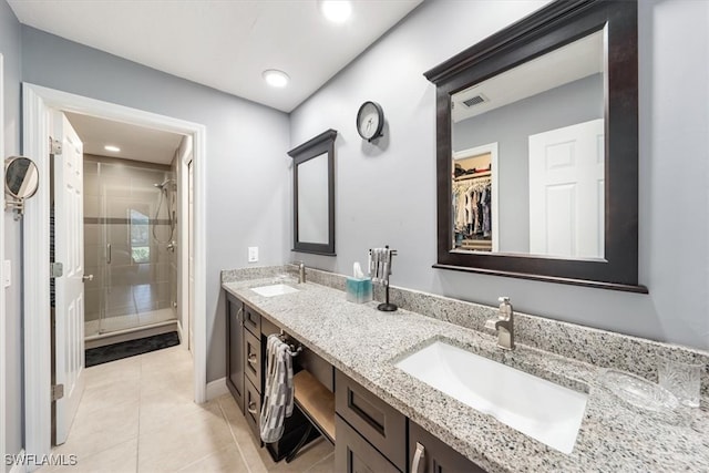 bathroom featuring tile patterned flooring, vanity, and walk in shower