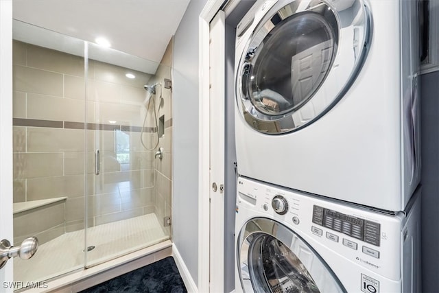 clothes washing area featuring stacked washer / dryer and tile patterned flooring