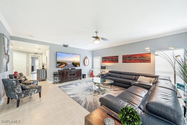 living room with a wealth of natural light, ceiling fan, light tile patterned flooring, and ornamental molding