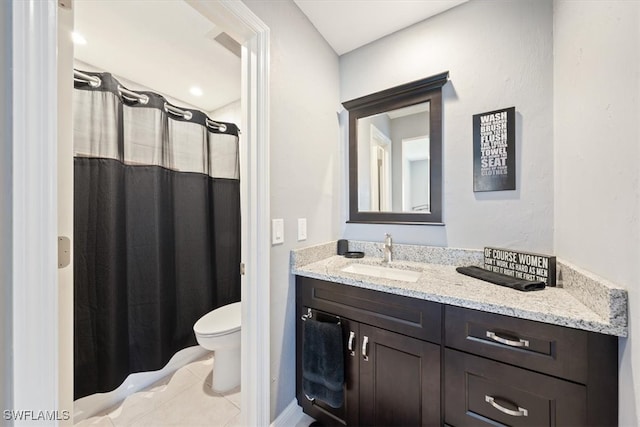 bathroom with tile patterned flooring, vanity, and toilet