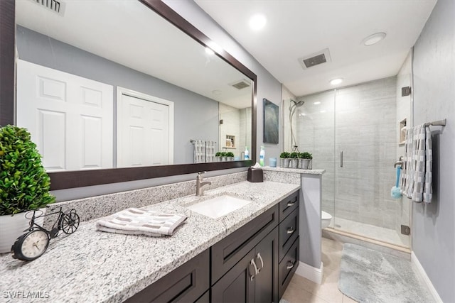 bathroom with tile patterned floors, vanity, toilet, and a shower with shower door