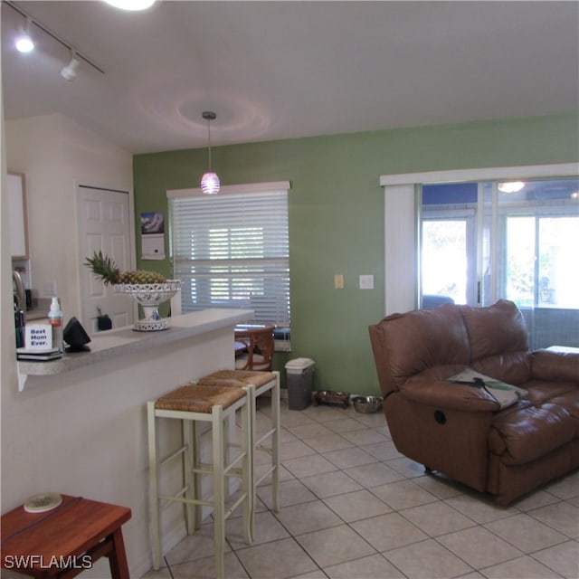 kitchen featuring a breakfast bar area, light tile patterned flooring, and hanging light fixtures