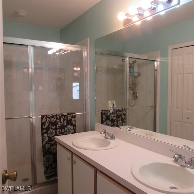 bathroom with a shower with door and vanity