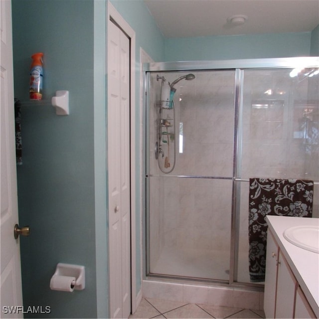 bathroom featuring tile patterned floors, vanity, and a shower with shower door