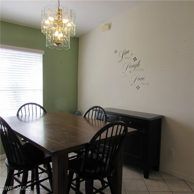 dining space with light tile patterned flooring and an inviting chandelier