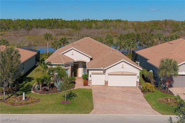 view of front of property with an attached garage, stucco siding, a front yard, concrete driveway, and a tiled roof