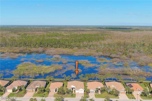 birds eye view of property featuring a water view, a residential view, and a forest view