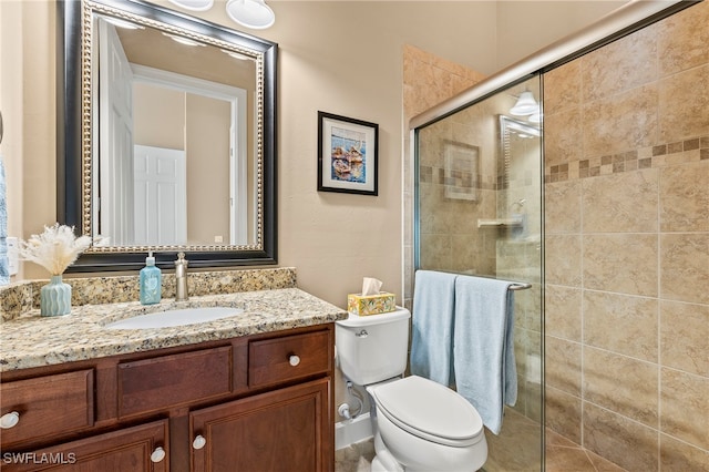 bathroom with toilet, an enclosed shower, and vanity