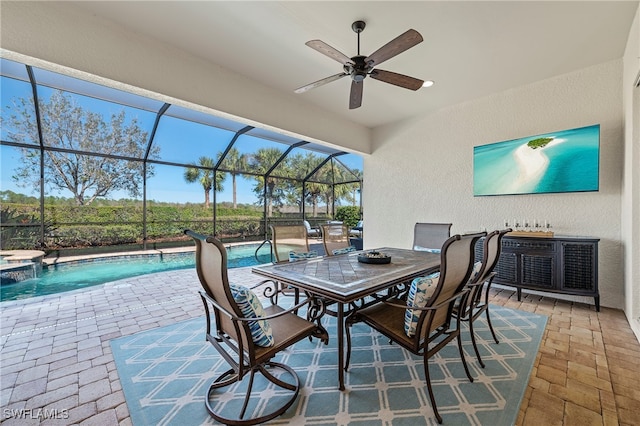 view of patio featuring ceiling fan, a swimming pool with hot tub, and glass enclosure