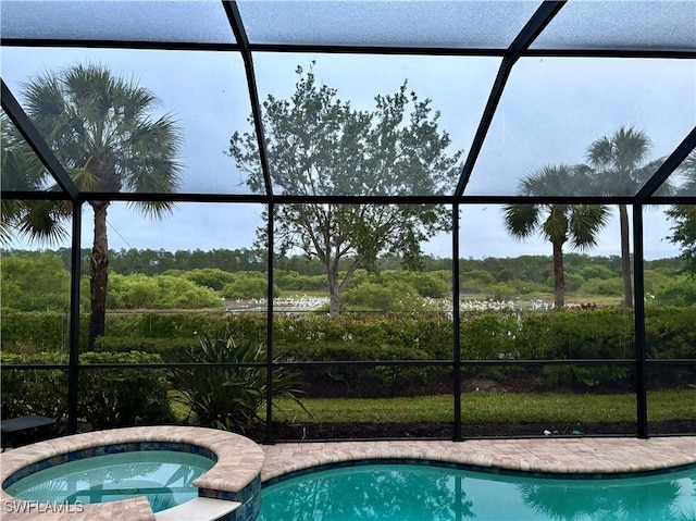 view of swimming pool featuring a lanai and a pool with connected hot tub