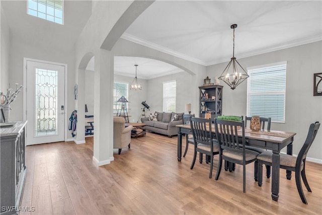 dining area with a chandelier, light hardwood / wood-style floors, and ornamental molding