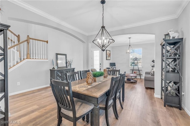 dining room with crown molding, an inviting chandelier, and hardwood / wood-style flooring