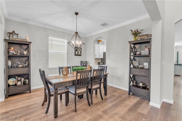 dining room with a notable chandelier, light hardwood / wood-style floors, and ornamental molding