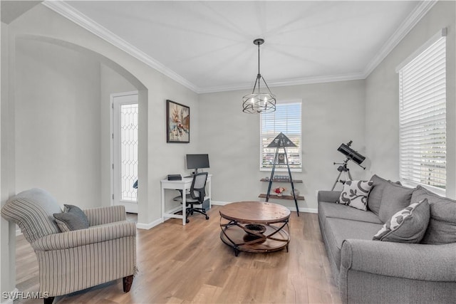 living room featuring hardwood / wood-style floors, ornamental molding, and a notable chandelier