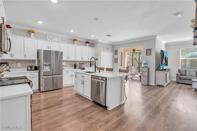 kitchen with white cabinets, sink, light wood-type flooring, and stainless steel appliances