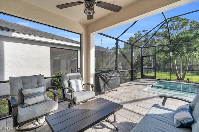 view of patio featuring a grill, ceiling fan, and glass enclosure