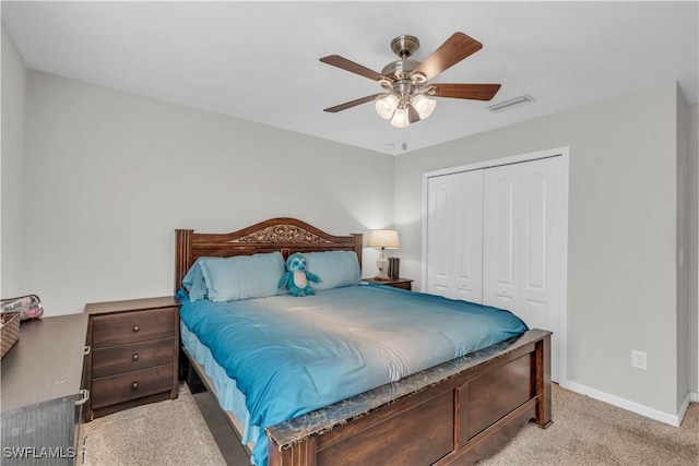 carpeted bedroom featuring ceiling fan and a closet