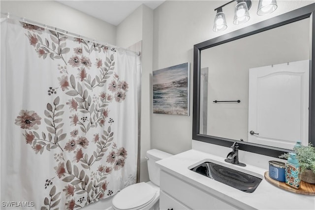 bathroom featuring a shower with shower curtain, vanity, and toilet