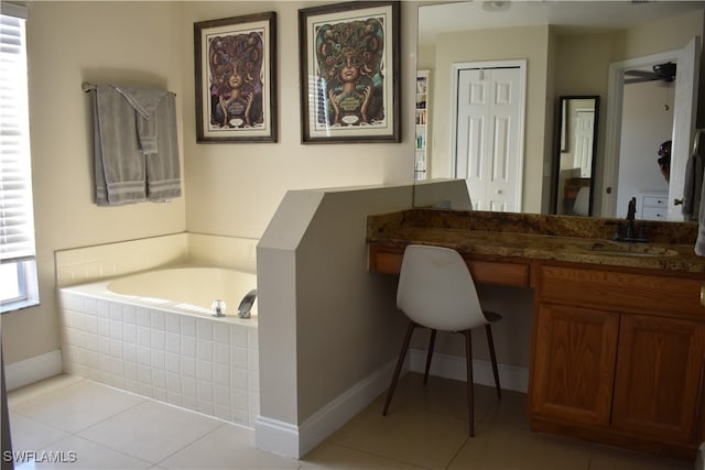 bathroom with tile patterned flooring, vanity, and tiled tub