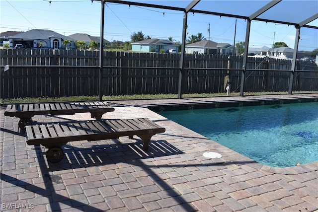 view of swimming pool featuring glass enclosure and a patio area