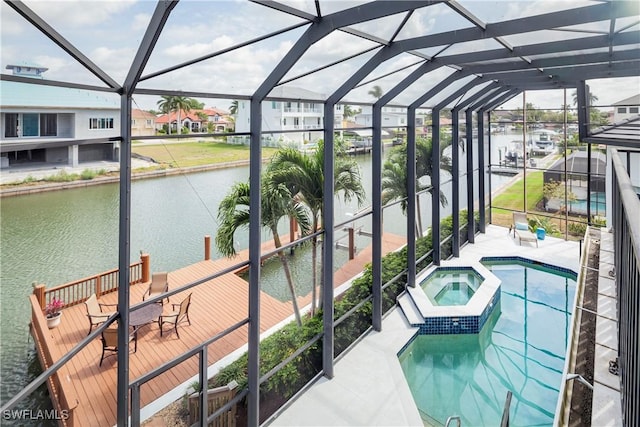 view of swimming pool with a lanai, an in ground hot tub, a water view, and a patio