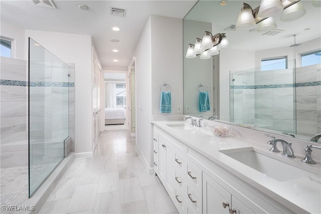 bathroom featuring plenty of natural light, tiled shower, and vanity